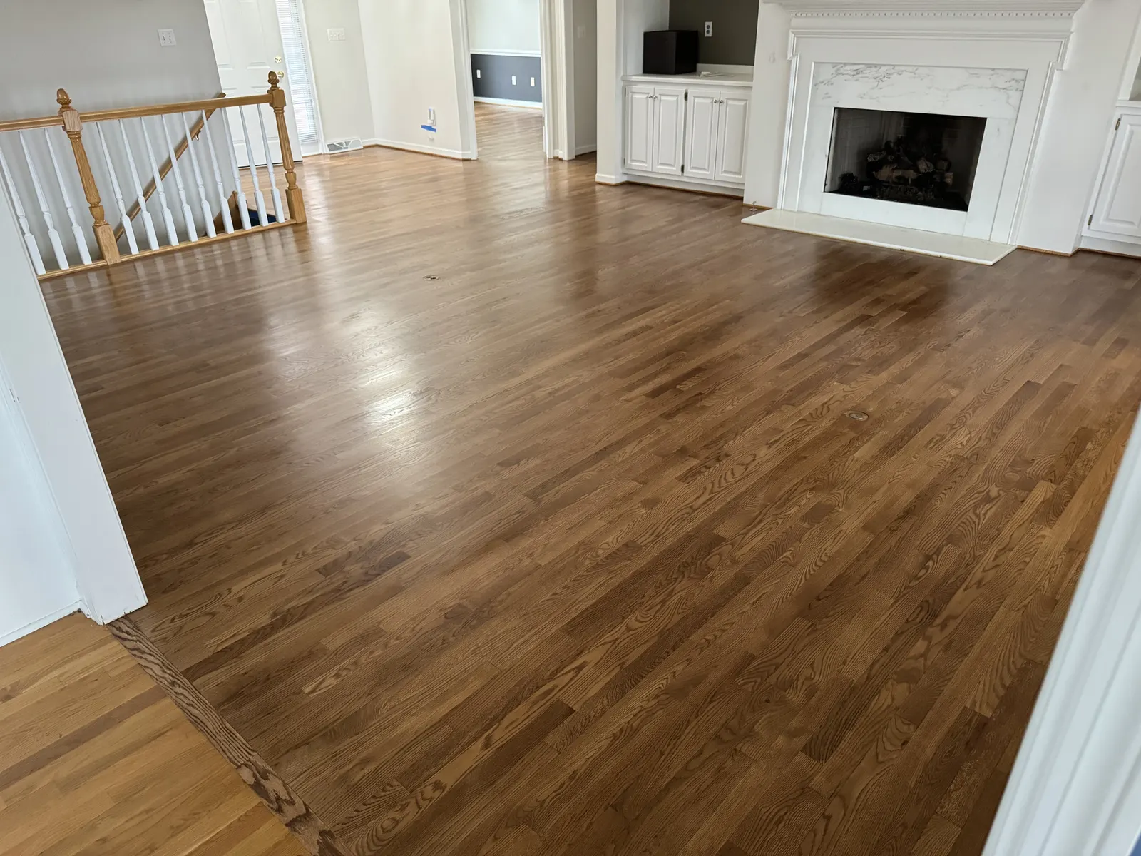 Refinished hardwood floor in a living room with a fireplace, Franklin, WI