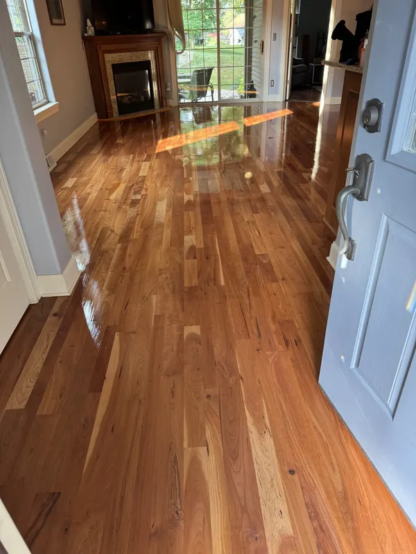 Refinished hardwood floor in a living room with a fireplace, Mukwonago, WI