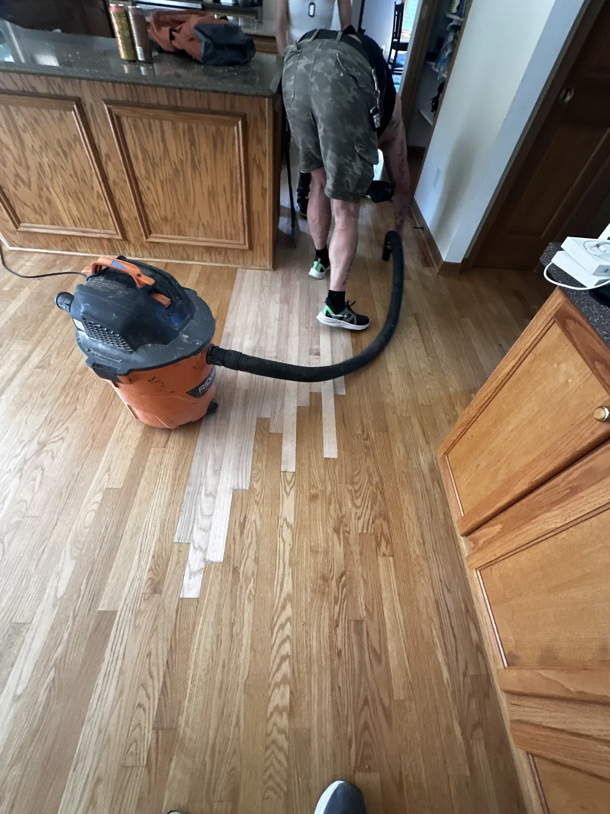 New boards laced into a kitchen hardwood floor after water damage