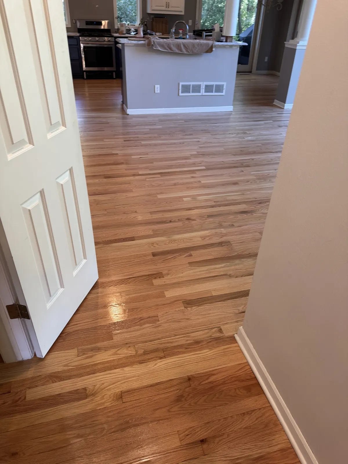 Refinished hardwood floor leading toward a kitchen, Pewaukee, WI