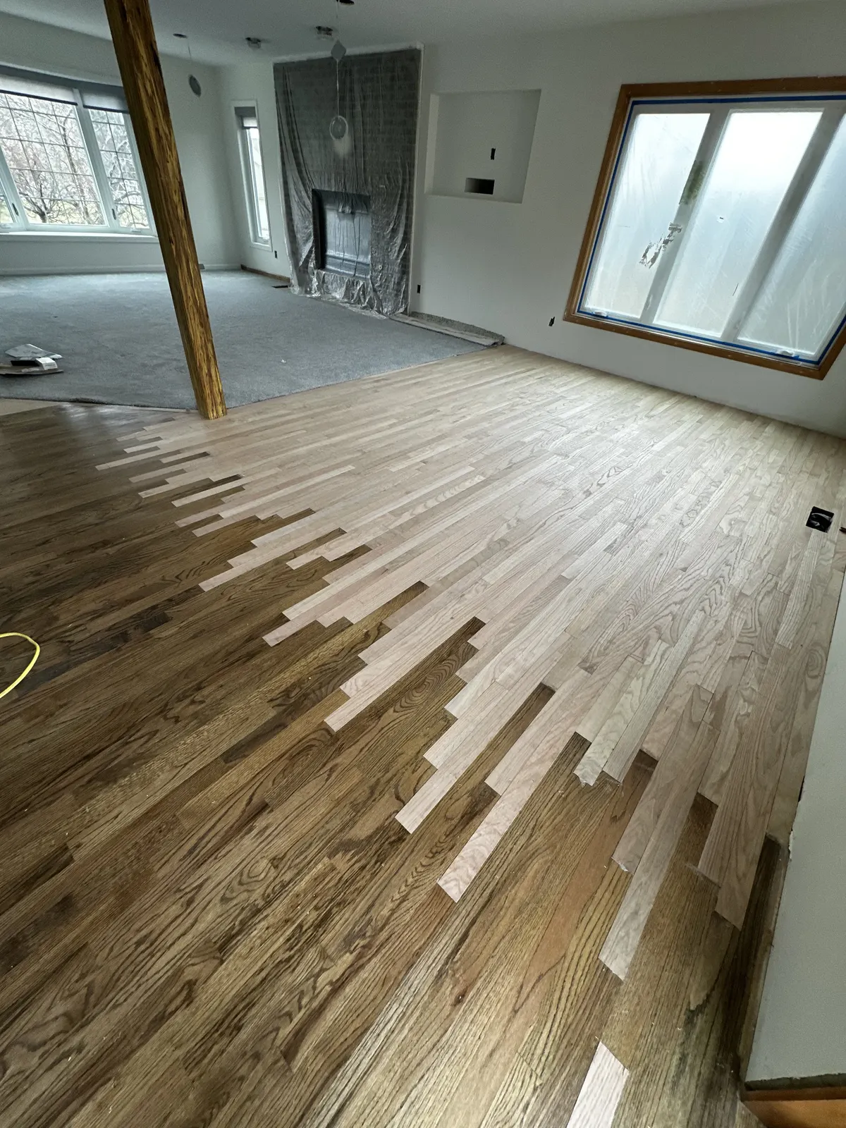 New boards weaved into an existing hardwood floor, ready to be sanded and blended