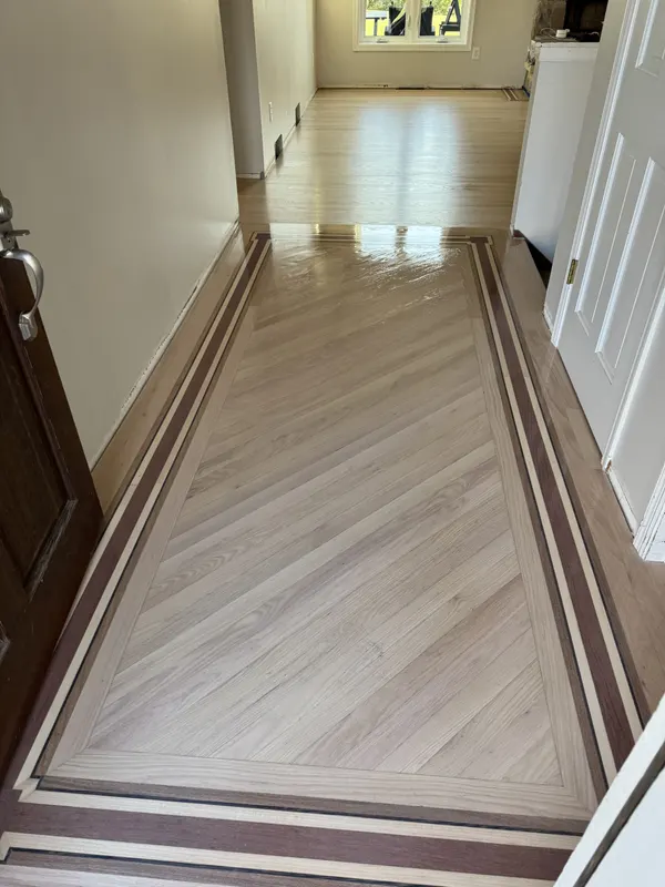 Refinished hardwood entry with an inlaid two-tone border, Pewaukee, WI