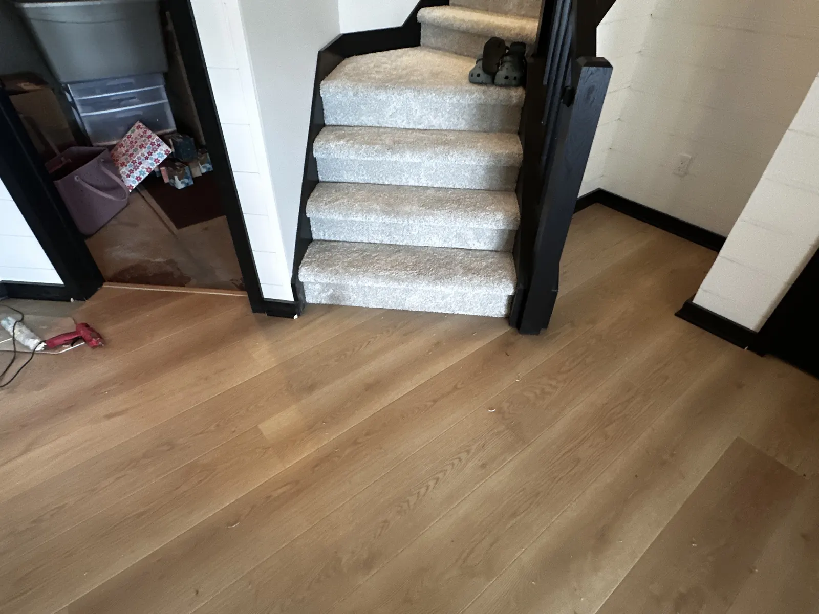 Luxury vinyl plank fitted around the base of a carpeted staircase